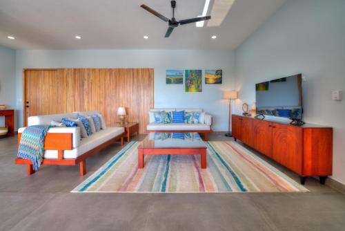 Habitación con cama, sofá y mesa. en Casa Ojos Azules, Nosara. New Listing, en Nosara