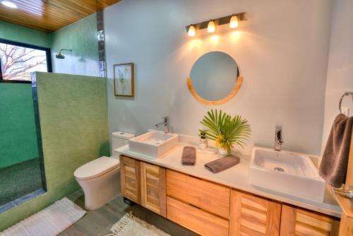 y baño con lavabo, aseo y espejo. en Casa Ojos Azules, Nosara. New Listing, en Nosara