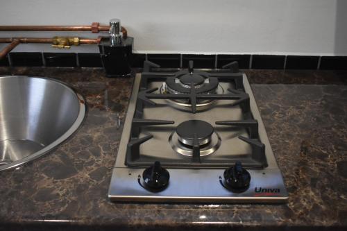 einen Herd mit Backofen auf einer Theke neben einem Waschbecken in der Unterkunft Langbeentjie Inn Two Point O in Kapstadt