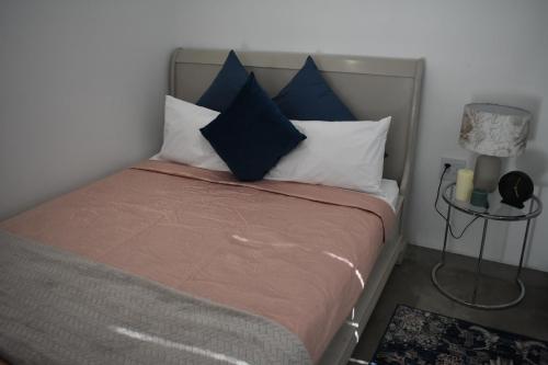 een slaapkamer met een bed met blauwe en witte kussens bij Langbeentjie Inn Two Point O in Kaapstad
