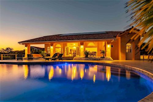 ein Haus mit einem Swimmingpool vor einem Haus in der Unterkunft Villa Magic Time - Oceanfront in Willibrordus