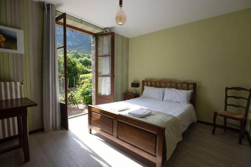 1 dormitorio con cama y ventana grande en Le Roucadel, en Peyreleau