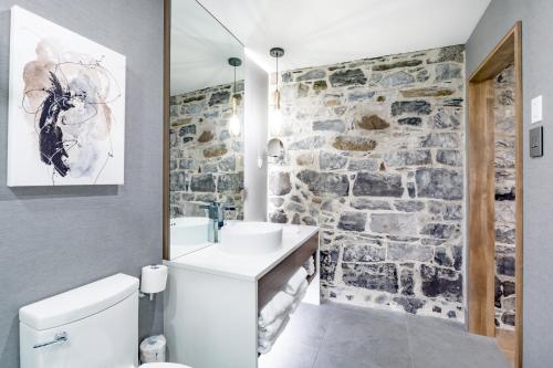 a bathroom with a stone wall at La Maison Kent - Par Les Lofts Vieux-Québec in Quebec City