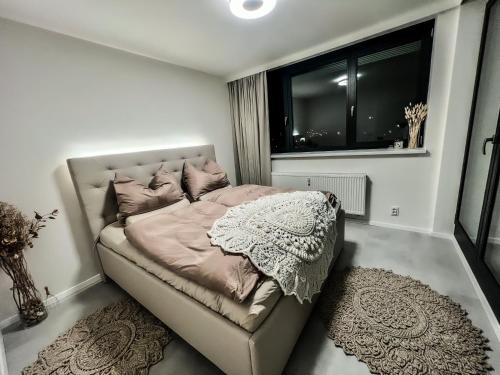 Dormitorio pequeño con cama y ventana en Luxury Penthouse Apartment, en Žďár nad Sázavou