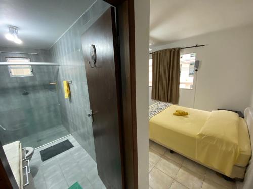 een badkamer met een douche en een slaapkamer met een bed bij Dambroso Residence in Balneário Camboriú