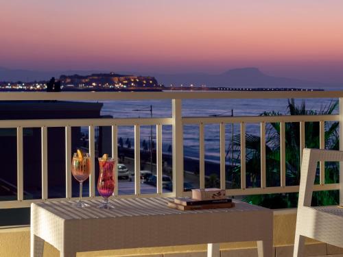 a balcony with a table and two wine glasses at Unique seaside apartment in Rethymno Town