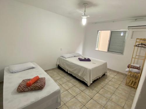 een slaapkamer met 2 bedden en een tegelvloer bij Dambroso Residence in Balneário Camboriú