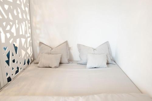 a bed in a room with white walls and pillows at Alternativ 1 Residence in Timişoara