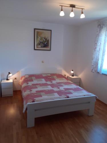 a bedroom with a bed with a quilt on it at Apartman Bonaca in Jadranovo