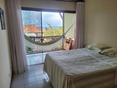 a bedroom with a bed and a large window at Flat 2A Hotel Monte Castelo Gravatá 2 quartos in Bezerros