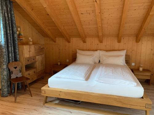 ein Schlafzimmer mit einem Bett in einem Holzzimmer in der Unterkunft Ferienwohnung Talhaus in Lauterbrunnen
