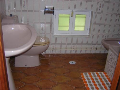 łazienka z białą umywalką i toaletą w obiekcie Casa con jardín en la playa de Almieiras w mieście Fene