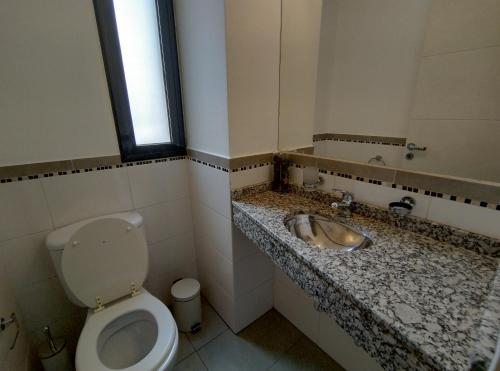 baño con aseo y lavabo y ventana en Independencia 880 Nueva Córdoba 2 hab 2 baños 2 a 5pax en Córdoba