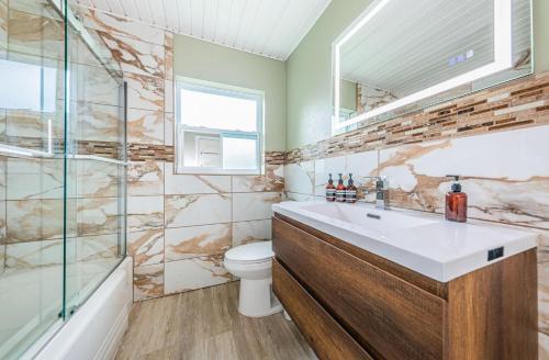 a bathroom with a sink and a toilet and a shower at Sunset Beach House in Clearwater Beach