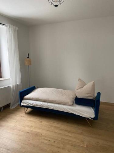 a bed sitting in a room with a blue chair at Ferienhaus Regenstein in Winterberg
