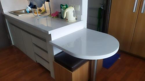 a white counter with a stool in a kitchen at Apartemen M Square 23m2 Jl. Cibaduyut No. 142 in Bandung