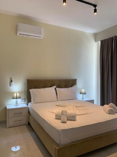 a bedroom with a bed with two towels on it at Dream Apartments Saranda in Sarandë