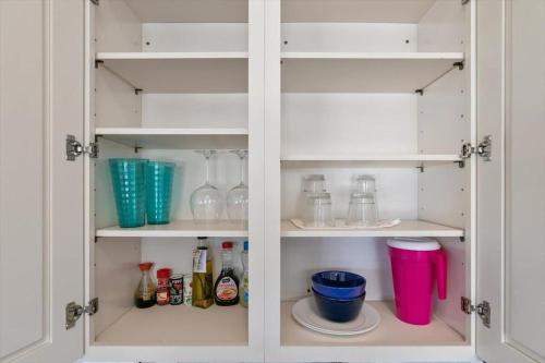 a white cabinet filled with bottles and jars at Unit 15 Maui Ohana Modern Studio in Wailuku