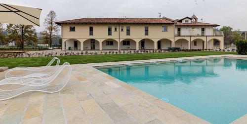 a swimming pool in front of a large house at L'aja della Mirusina - Piedmont Resort Monferrato Langhe in Canelli