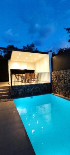 una piscina frente a una casa por la noche en Villa Porto - Βίλα με ιδιωτική πισίνα, en Porto Rafti