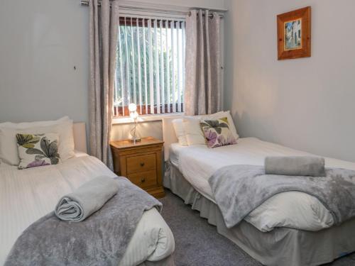Un dormitorio con dos camas y una ventana. en Boathouse, en Deganwy