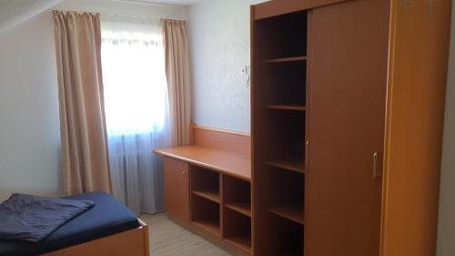 a bedroom with a closet and a bed and a window at Monteurzimmermit Gemeinschafst Bad-Küche- AM RHEIN in Greffern