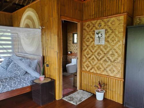 - une chambre avec un lit et des toilettes dans l'établissement Luxury Bahay Kubo in a Farm Near Tagaytay, à Tagaytay