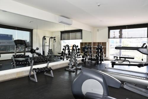 a gym with a lot of treadmills and machines at Fato Hotel in Querétaro