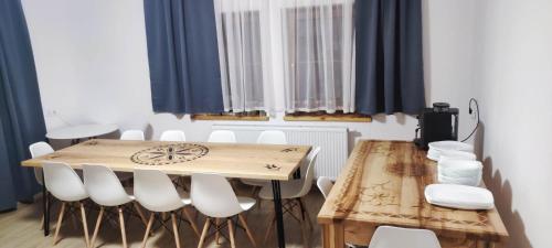 a dining room with a wooden table and white chairs at Villa U Skupniów Suche-Zakopane in Poronin
