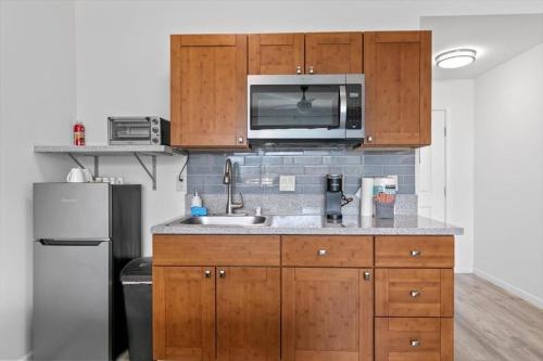 a kitchen with a sink and a microwave at Unit 17 Maui Ohana Modern Studio in Wailuku