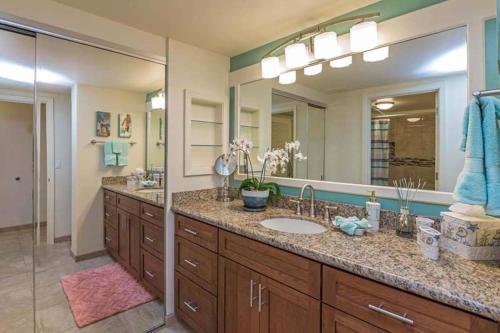 a bathroom with a sink and a large mirror at Hanalei Bay Resort BaliHi in Princeville