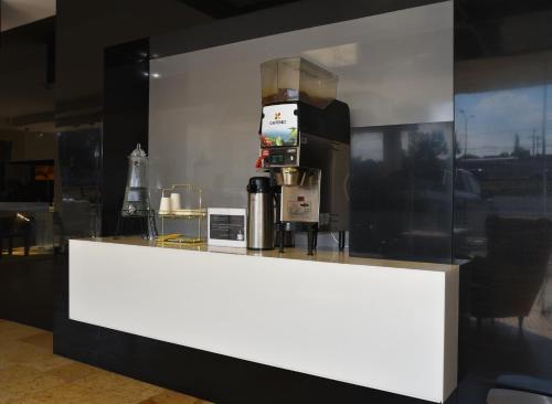 a white counter with a coffee maker on it at Fato Hotel in Querétaro