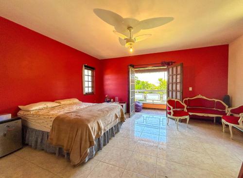 um quarto com uma cama grande e paredes vermelhas em Incrivel casa com churrasq em Miguel Pereira RJ em Miguel Pereira