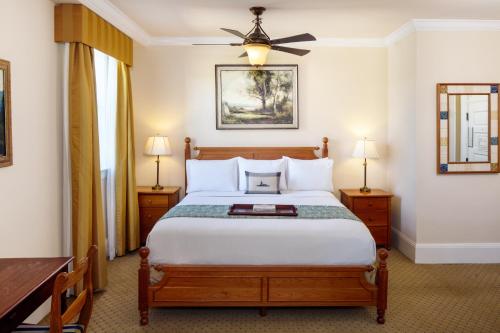 a bedroom with a bed and a table and two lamps at Historic Boone Tavern in Berea