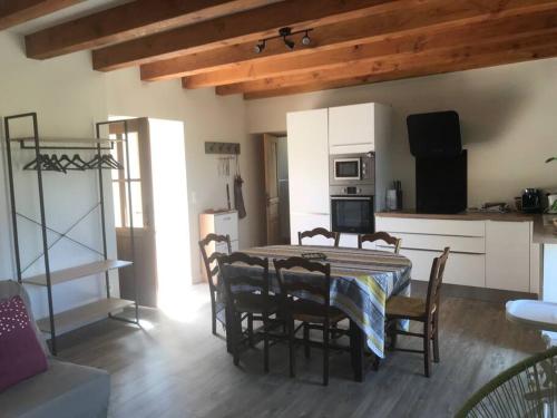 une cuisine avec une table et des chaises dans une pièce dans l'établissement Maison de charme Sarladais Perigord noir Bouzic, à Bouzic