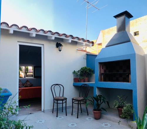 a patio with two chairs and a fireplace at Chalet Pura Vida in Mar del Plata