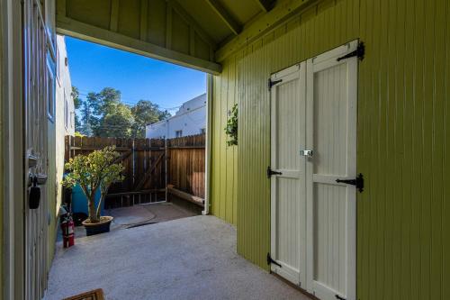 a green house with a door and a fence at @ Marbella Lane - Adorable and Quiet Studio in San Mateo