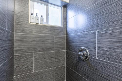 a bathroom with a shower with brown tiles at @ Marbella Lane - Adorable and Quiet Studio in San Mateo