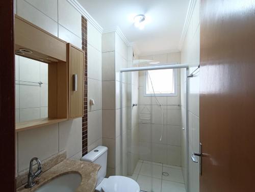 a bathroom with a shower and a toilet and a sink at Apê com churrasqueira guilhermina in Praia Grande