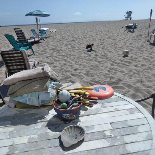 a beach with a table and chairs and a volley ball at Beautiful Ocean Front Coastal Sunset Beach House in Oxnard