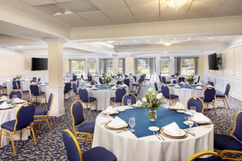 a ballroom with tables and chairs and a room filled with at Historic Boone Tavern in Berea