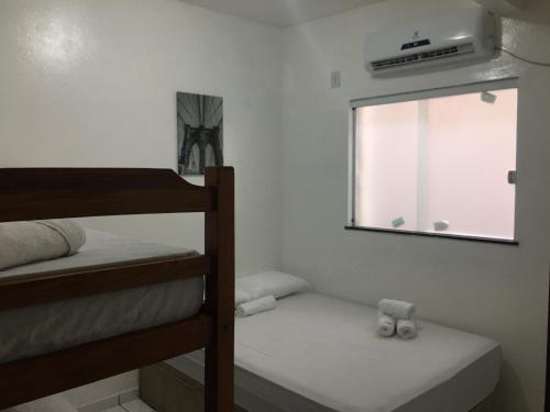 a bedroom with two bunk beds and a window at Casas do Matteo - 2ª Praia in Morro de São Paulo