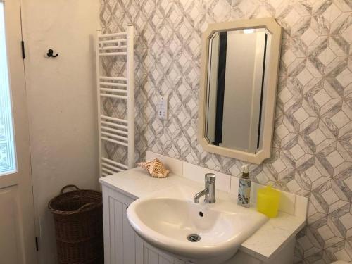 a bathroom with a sink and a mirror at Cosy cottage near Hartland Village in Bideford