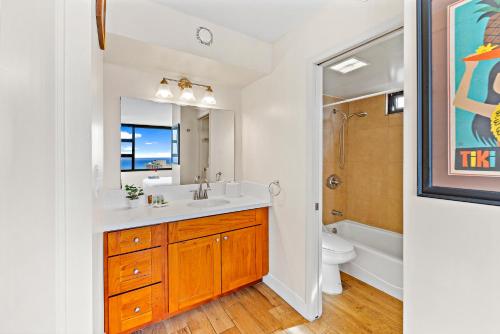 a bathroom with a sink and a toilet and a mirror at 30FL Great Ocean Views with Lanai, King bed, Parking in Honolulu