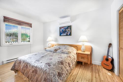a bedroom with a bed and a guitar in it at Quiet place in the heart of Laurentides in Sainte-Lucie-de-Doncaster