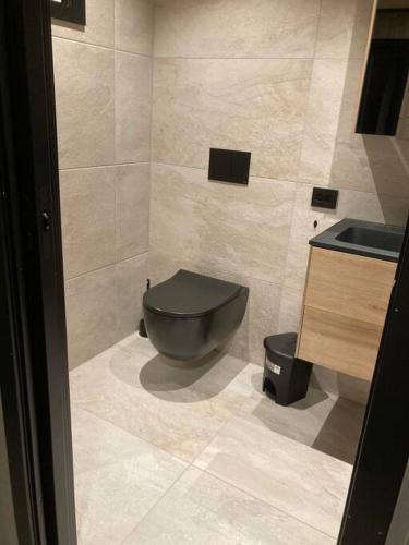 a bathroom with a black toilet and a sink at Høy standard med nydelig utsikt in Alta