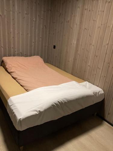 a unmade bed in a room with a wall at Høy standard med nydelig utsikt in Alta