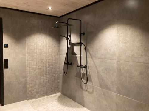 a shower in a bathroom with a tiled wall at Høy standard med nydelig utsikt in Alta