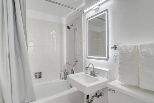 a white bathroom with a sink and a mirror at Newly Renovated 1 Bedroom Apartment near Downtown in Gadsden