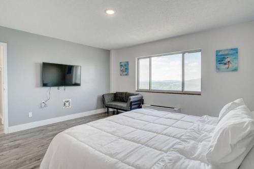 a white bedroom with a large bed and a tv at Newly Renovated 1 Bedroom Apartment near Downtown in Gadsden